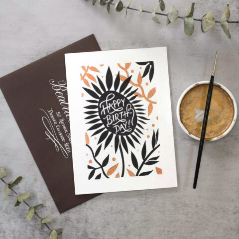 A floral modernist birthday card with shimmery bronze tones, sumi ink, masking fluid, and a brown and white calligraphed envelope