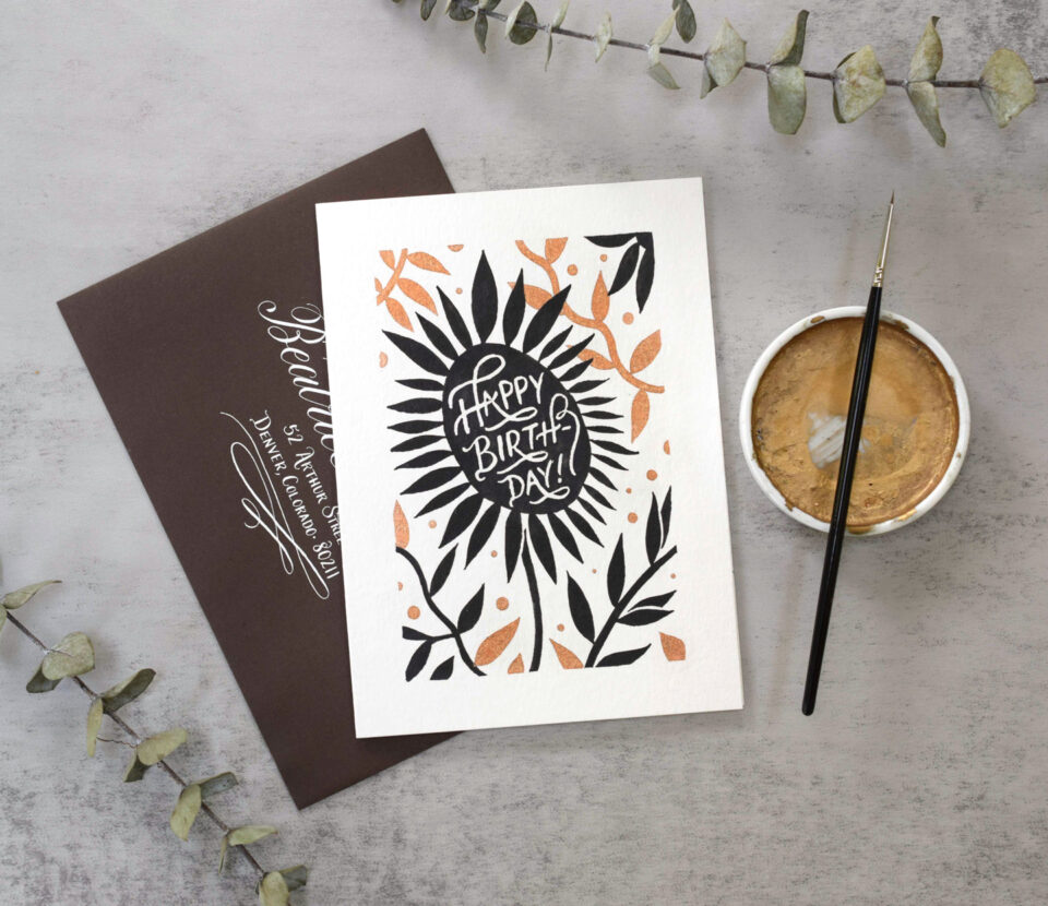 A floral modernist birthday card with shimmery bronze tones, sumi ink, masking fluid, and a brown and white calligraphed envelope